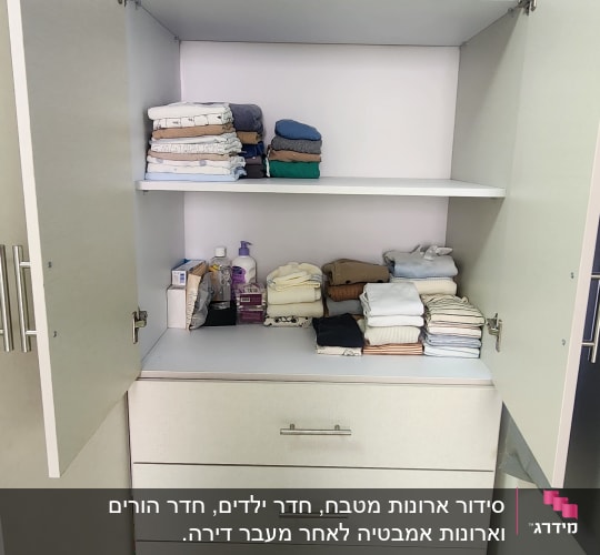 ארון פתוח עם מדפים, מגבות מקופלות ומוצרי טיפוח